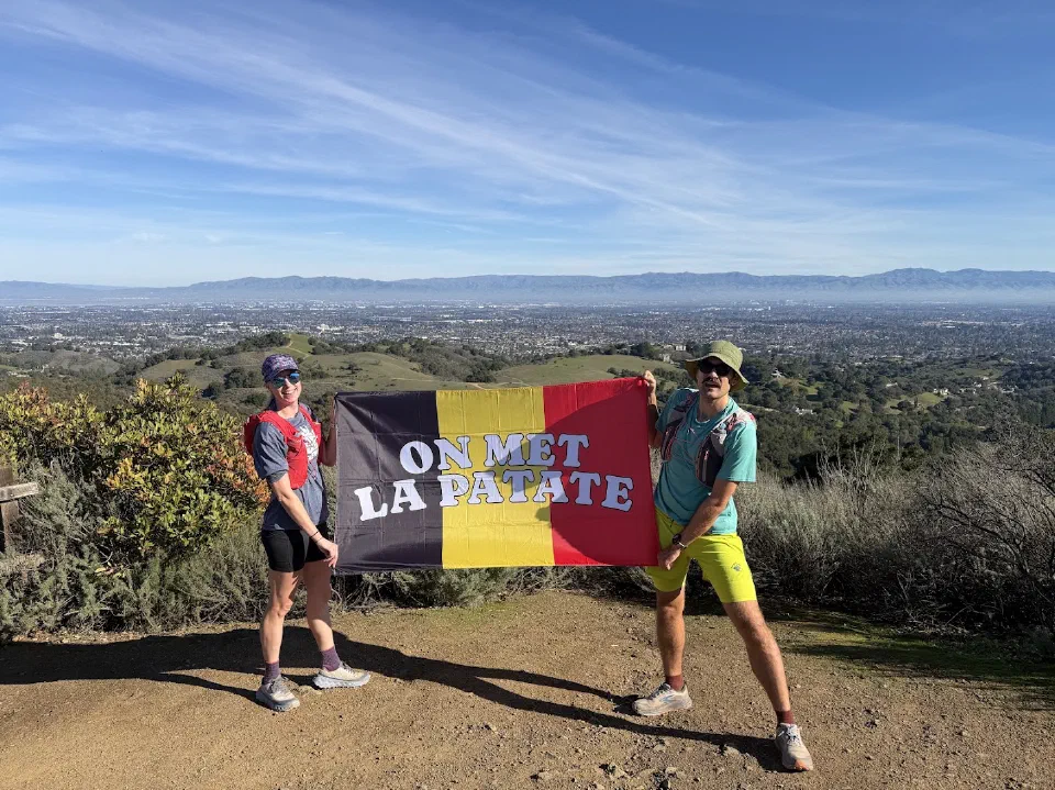 Kelly and Nills holding a Belgian flag on a California trail